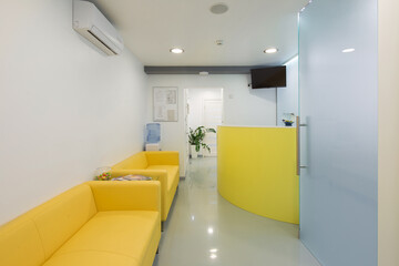 Bright and Inviting Reception Area Featuring Yellow Sofas, a Water Cooler, and Modern Decor for a Comfortable Guest Experience
