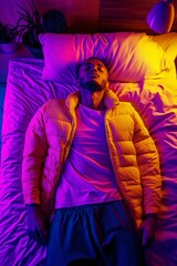 Young Man Relaxing on Bed Under Colorful Neon Lights