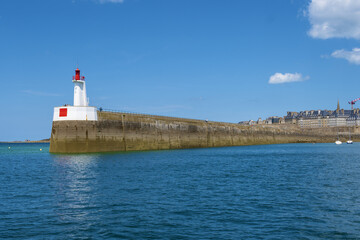 lighthouse at the entrance to the harbor and bulwark and patrician houses of Saint Malo, Brittany,...