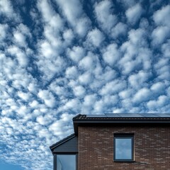 modern brick house against a blue sky with altocumulus clouds