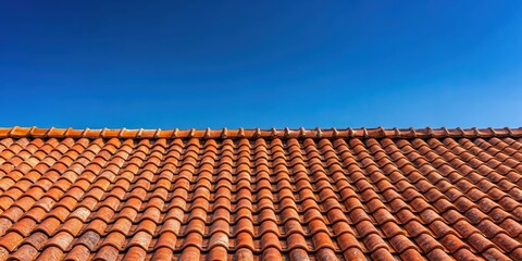 Weathered red tile roof under midday sunlight on blue sky background, blue sky
