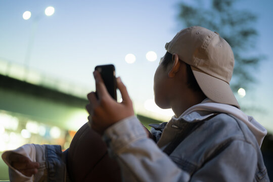 夕方にバスケットボールとスマホを持って写真を撮る、音楽を聴く、sns投稿する男の子　顔無しのイメージ　