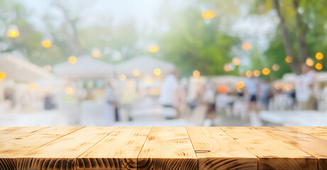 Wooden table in the foreground with a blurred background of an outdoor market or garden party.ideal...