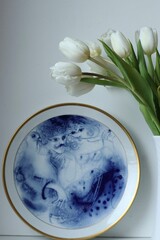 Biale tulipany i niebieski talerz. Ceramika i kwiaty. piękny styl w domu