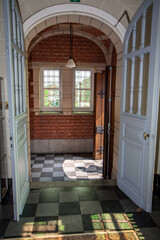 An exquisitely illuminated entrance showcasing a beautiful classic design along with striking checkered flooring