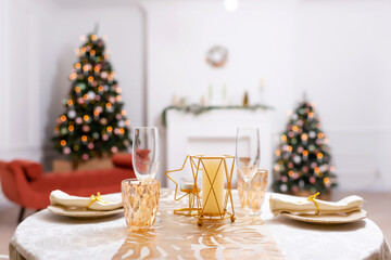 New Year's table setting in a photo studio. Plates with glasses on a Christmas tablecloth