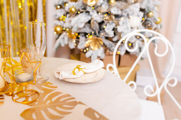 New Year's table setting in a photo studio. Plates with glasses on a Christmas tablecloth