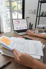 Accountant analyzing budget pie chart and reviewing financial documents.
