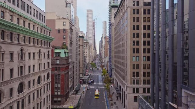 Manhattan cityscape with yellow cabs weaving through bustling Fifth Avenue, depicting peak morning traffic under golden fall light