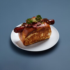 Gourmet Hot Dog with Bacon and Herbs on White Plate Against Blue Background