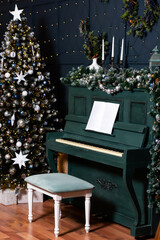 green piano blue wall decorated with christmas tree decor. classic christmas photo zone with piano