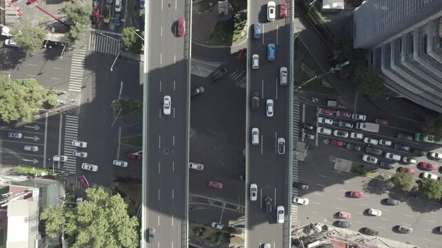 Overhead drone video of a multi-level car intersection with many vehicles crossing simultaneously