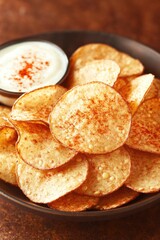 Crispy potato chips served with creamy dip, sprinkled with papri