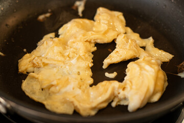 Close up of scrambled omelet egg in a black pan