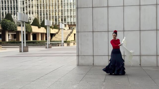 Flamenco dancer is performing a typical andalusian dance in front of a modern white wall