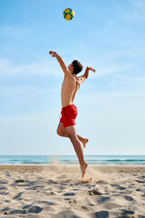 Young man playing beach volleyball on a sunny day