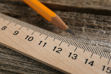 Ruler and pencil on wooden table, closeup