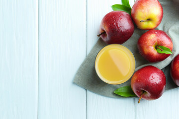 Refreshing apple juice in glass and fruits on white wooden table, flat lay. Space for text