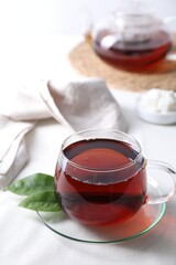 Refreshing black tea in cup on light table