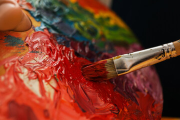 Man with palette and paintbrush, closeup view