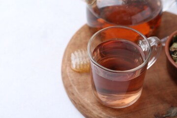 Delicious herbal tea with honey on white table. Space for text
