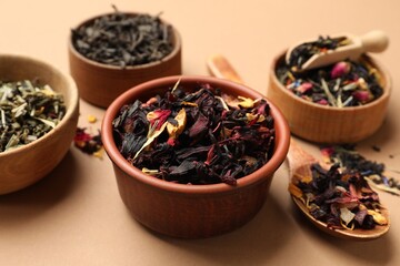 Different types of tea brew on brown background, closeup