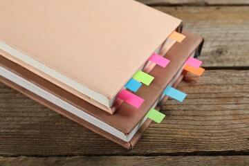 Books with colorful tabs on wooden table, closeup