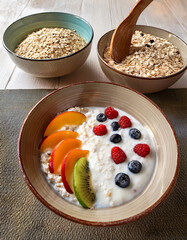 Porridge cr&eacute;meux aux flocons d&rsquo;avoine avec yaourt et fruits frais, servi dans un bol rustique