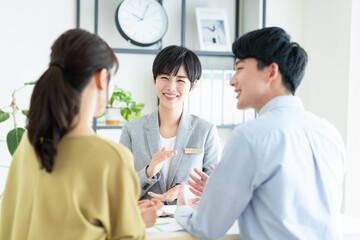 Obraz premium 若い夫婦に営業するビジネスウーマン