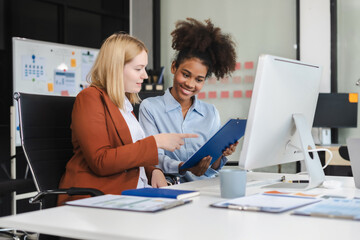Diverse businessmen write project ideas and use laptops to edit papers for brainstorming sessions with partners in the office.