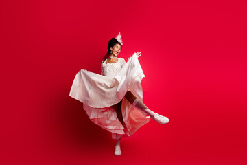 Photo of lady actress princess in antique style dress dancing moving isolated red color background