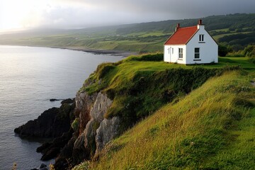 a house sits atop a cliff overlooking the ocean