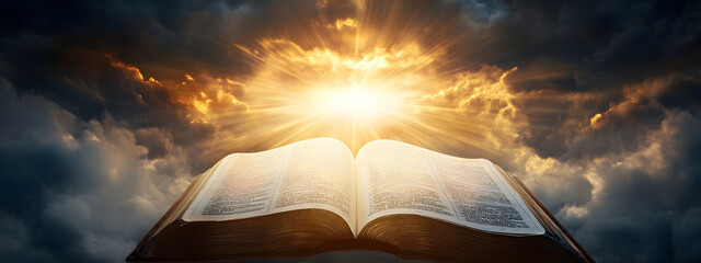 An open Bible with rays of light shining down on it, the background is dark and cloudy
