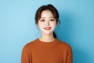 Young woman portrait smiling on blue background.