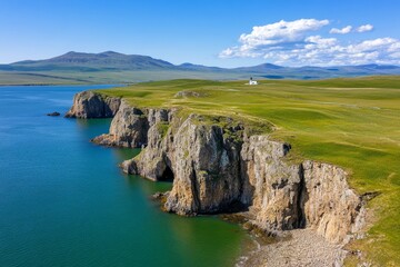 Fototapeta premium A breathtaking aerial view of cliffs meeting the ocean, with a lighthouse perched at the edge