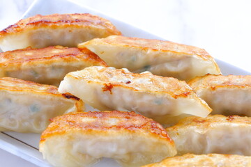 外がパリパリ、中がジューシー、焦げ目がおいしそうな焼きギョウザ
