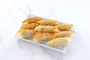 外がパリパリ、中がジューシー、焦げ目がおいしそうな焼きギョウザ

