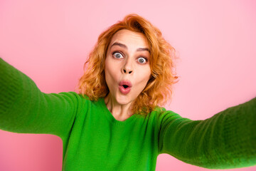 Excited Young Woman With Curly Red Hair in Green Sweater Making a Surprised Expression on Pink...