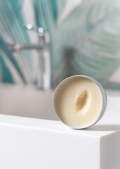Opened body butter jar on washbasin in green tropical bathroom close up, herbal cosmetic mockup