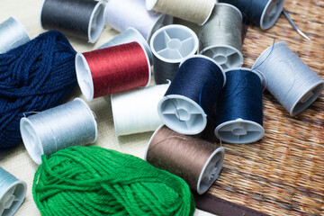 Colorful threads are all over the floor. There are needles ready to use