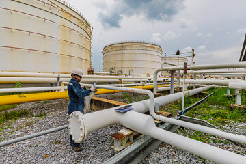 Male worker inspection at steel long pipes and pipe elbow in station oil factory during refinery...