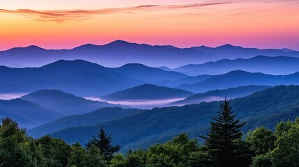 Obraz premium A beautiful sunrise over a misty mountain range, soft pink and orange hues filling the sky.