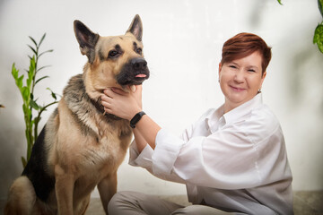 Middle-aged woman enjoys cozy time with her German Shepherd in a home setting