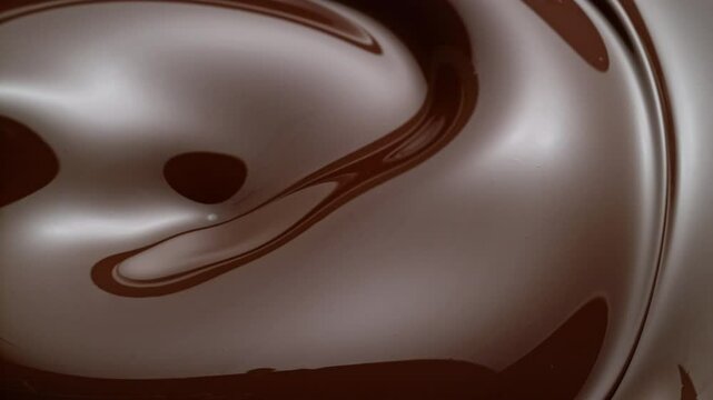 hazelnuts pouring into swirling liquid chocolate