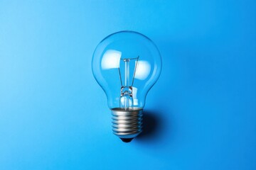 A Bright Electric Light Bulb Isolated on a Blue Backdrop