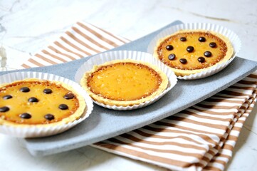 The image features a close-up shot of four egg tarts, also known as 