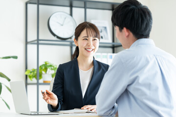 Fototapeta premium 若い男性に提案するビジネスウーマン