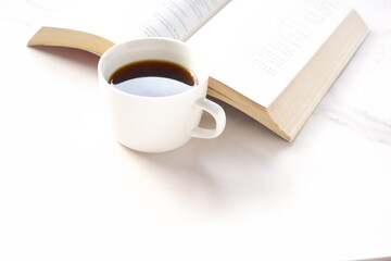 コーヒーを飲みながら、のんびりペーパーバック（洋書）を読んでいるイメージ
