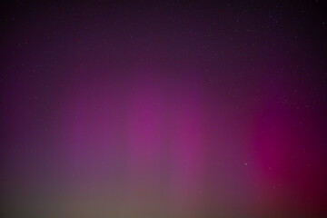 Fototapeta premium beautiful colorful aurora borealis over fields and meadows. amazing phenomenon in the sky at night in Poland. dark sky at night, colors in the night sky. magnetic storm.