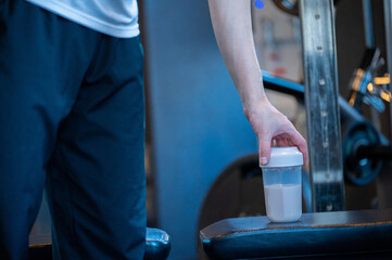 ジムでプロテインを持つ日本人男性の手元